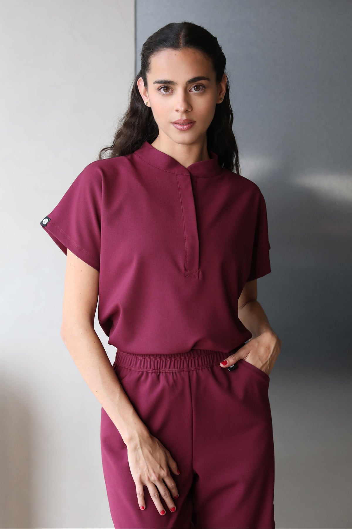 Woman wearing Glam Burgundy Scrub Top by Work & Chill