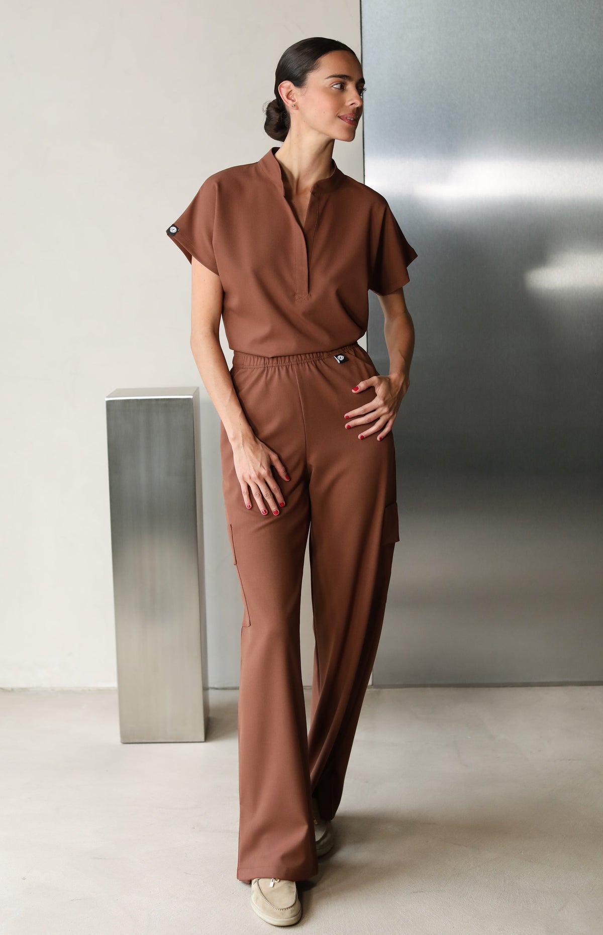 Model wearing Glam Cocoa Scrub Top with matching scrub pants