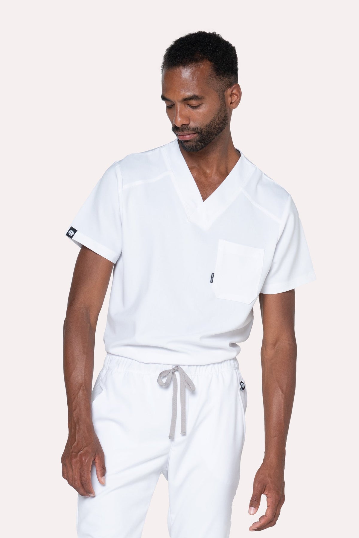Three-quarter view of Fresh White Scrub Top showing the relaxed fit and V-neckline
