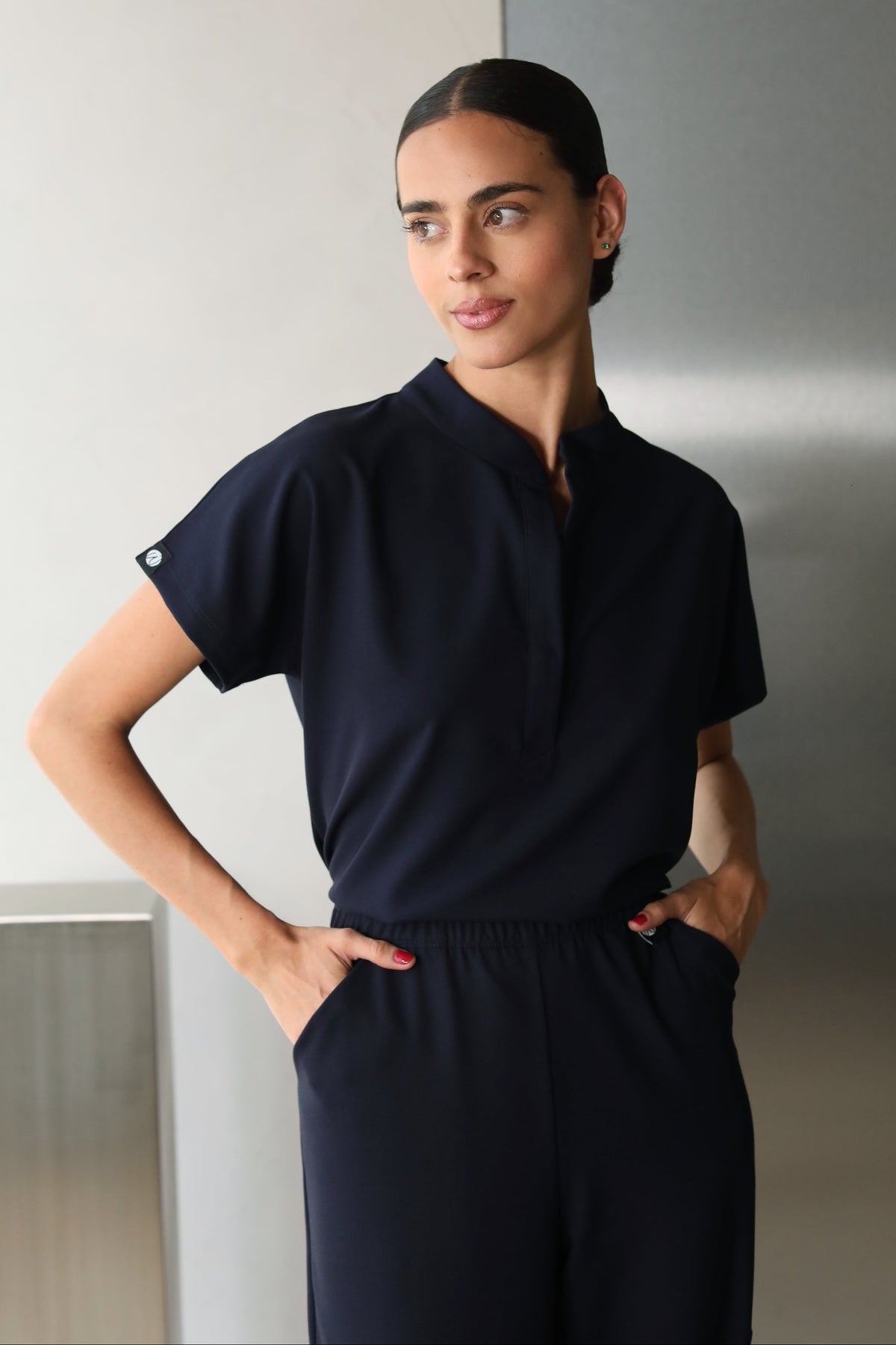 Woman wearing Glam Navy Scrub Top by Work & Chill
