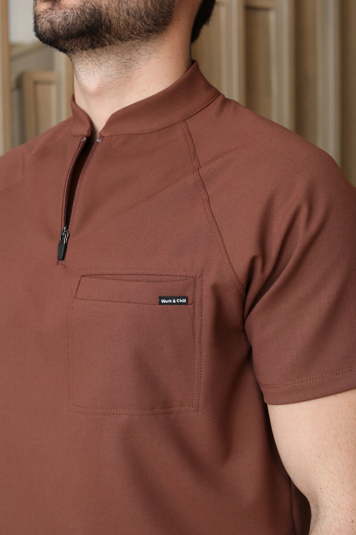 Close-up of Harry Cocoa Scrub Top showing the high collar and zipper neckline