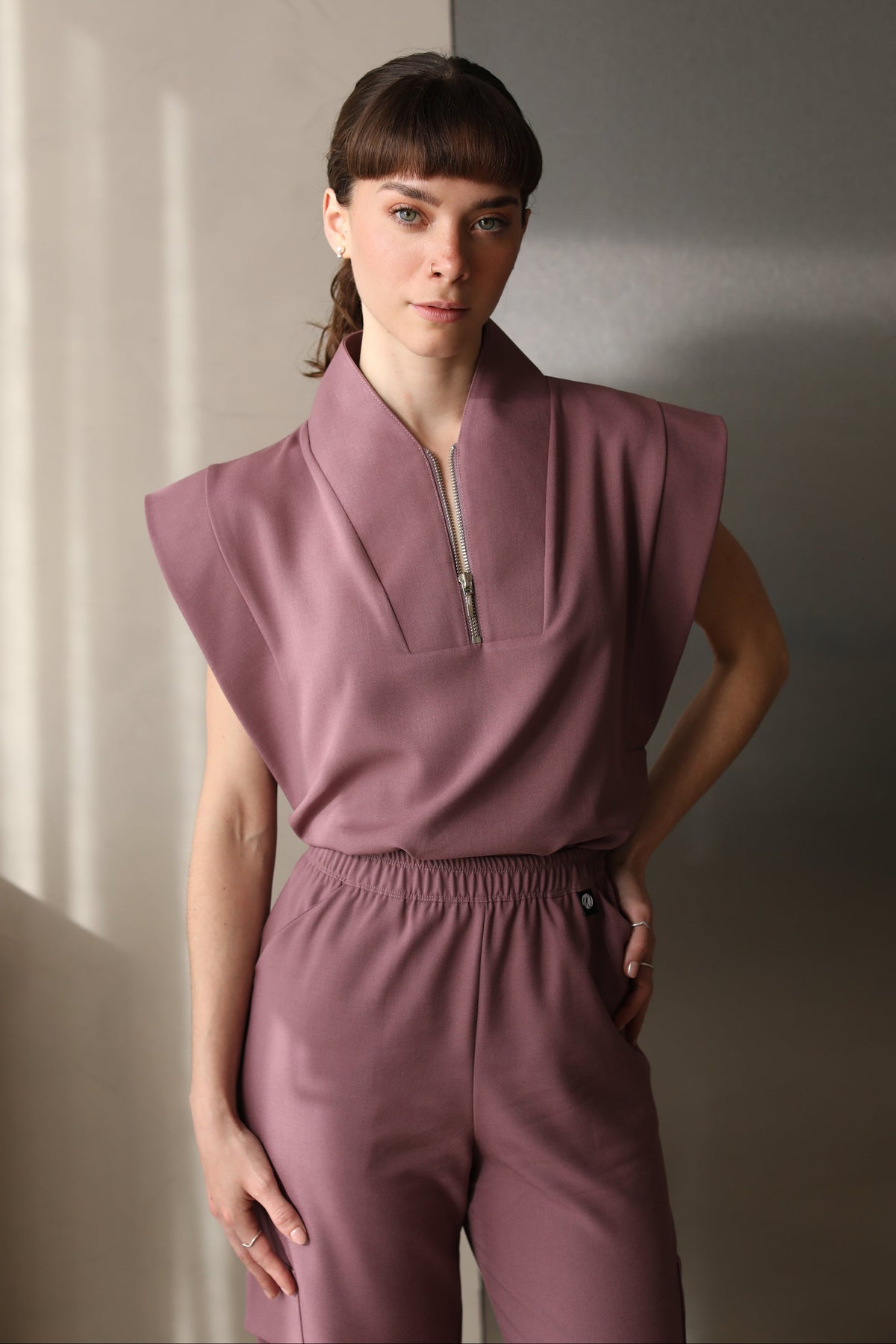 Woman wearing Kate Mauve Scrub Top by Work & Chill